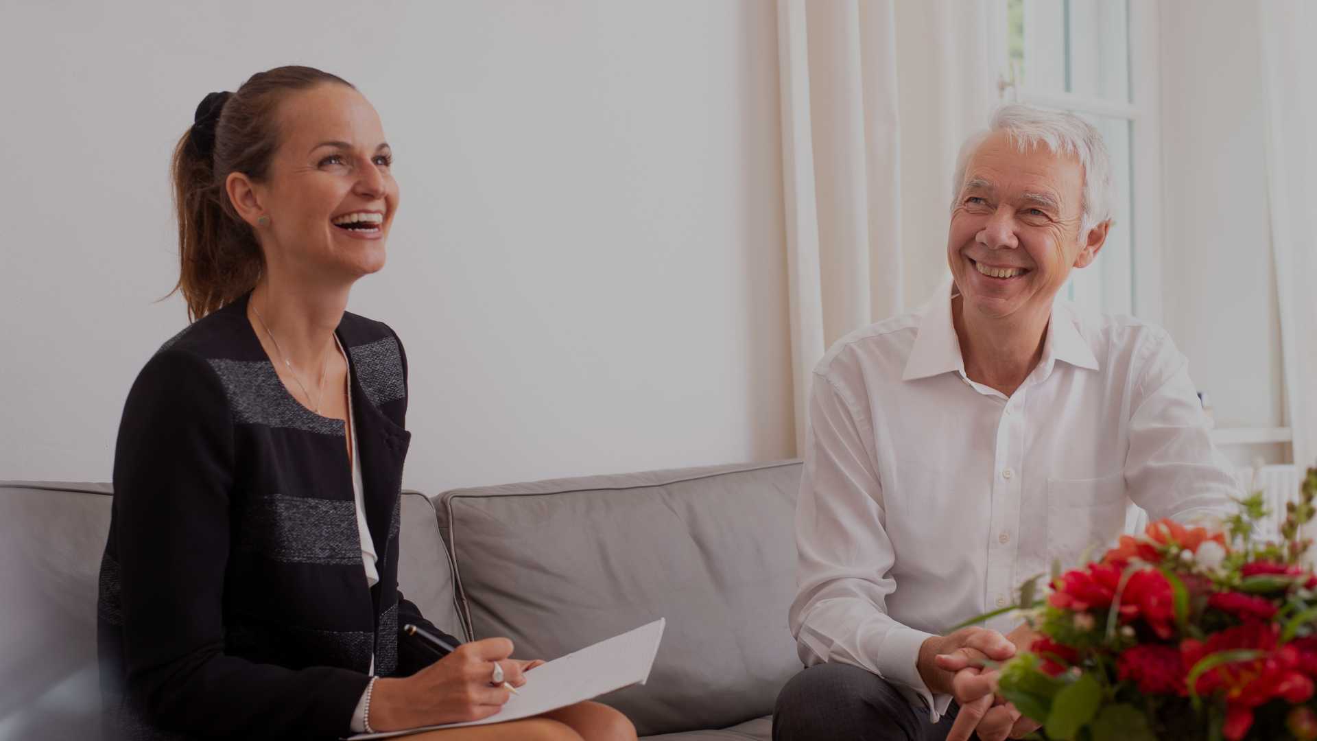 Eine Dame und ein Herr sitzen auf einem Sofa